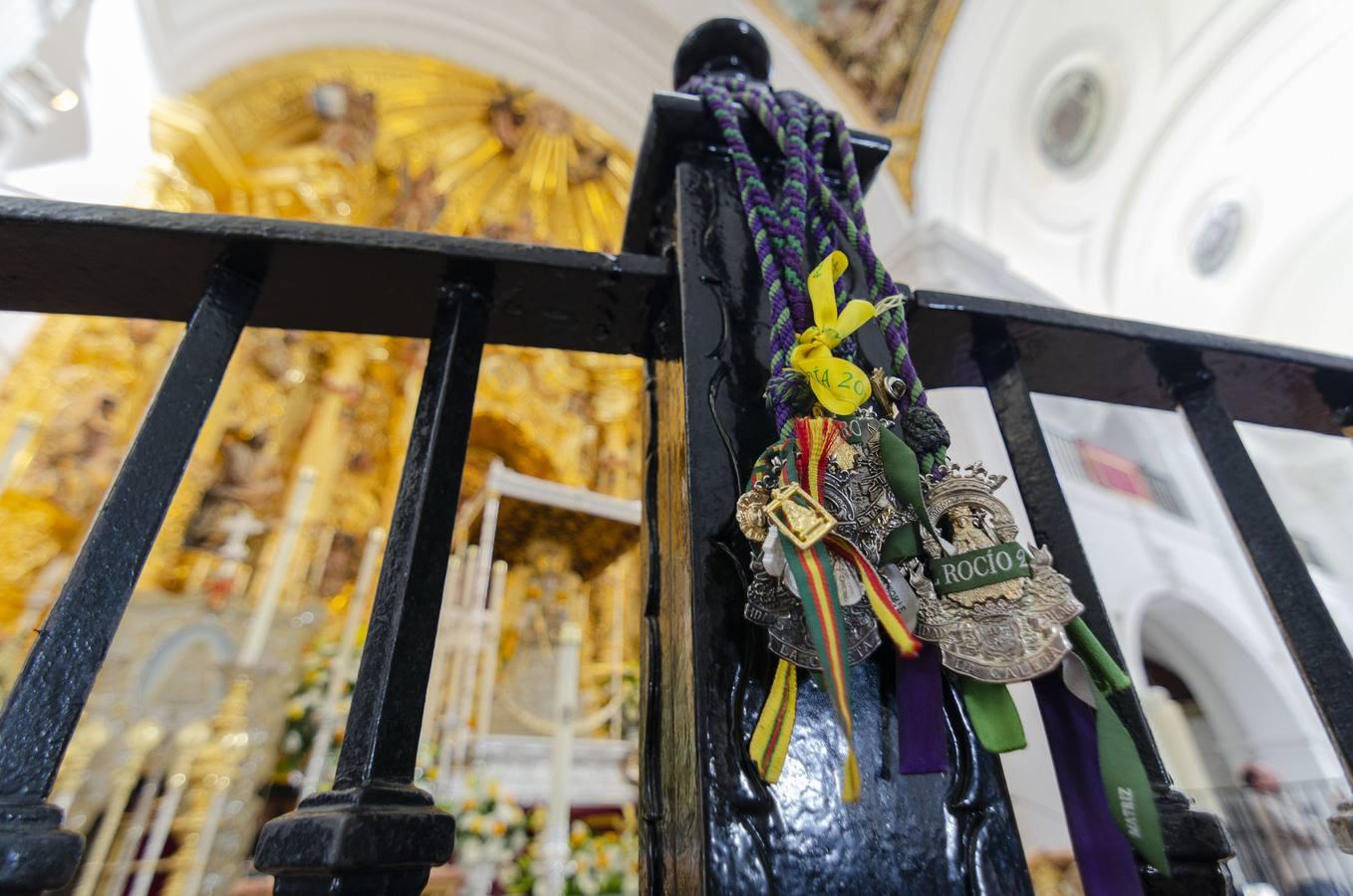 Diversas medallas colgadas en la reja ante la Virgen