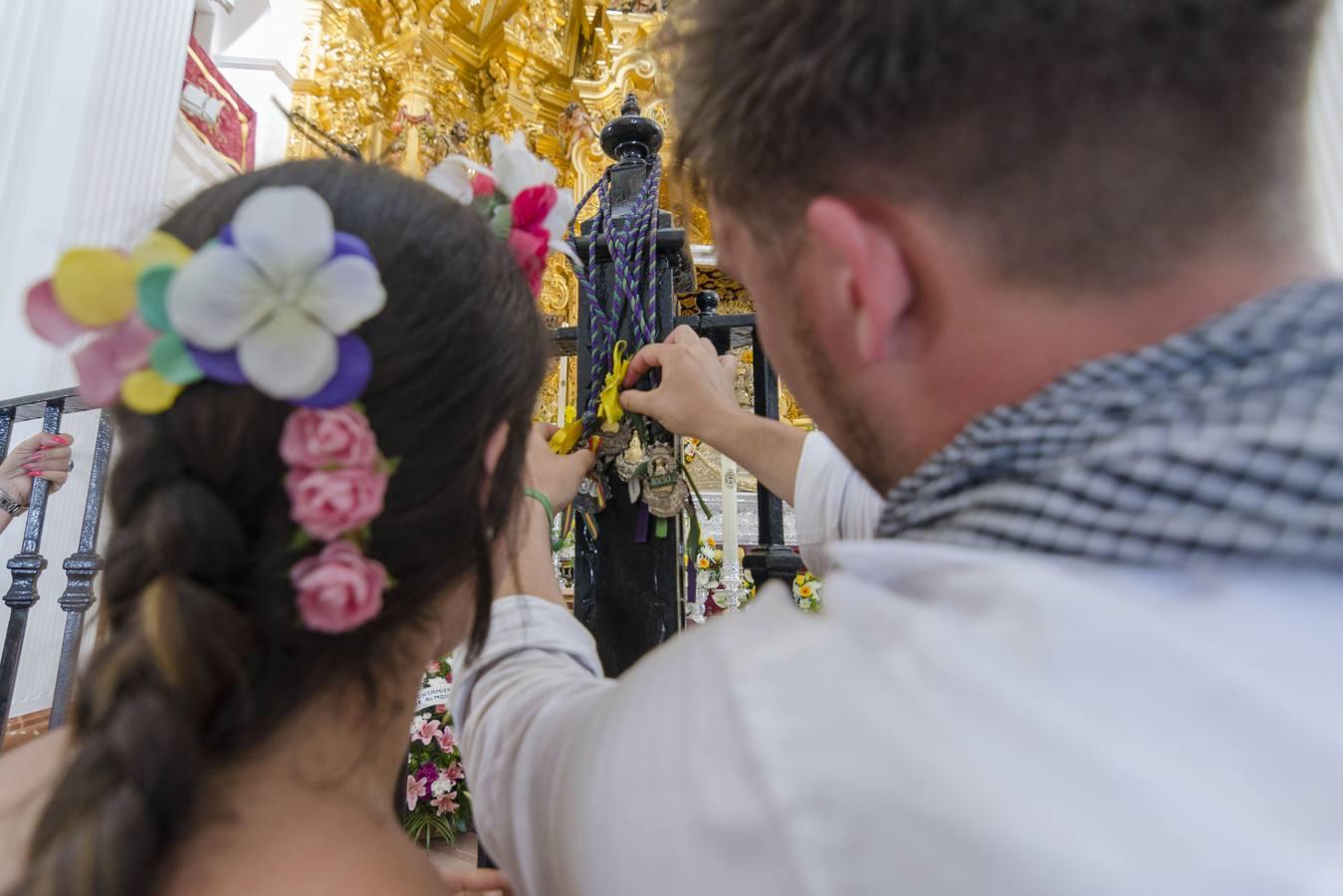 Peregrinos colgando medallas en la reja de la Virgen para recibir su bendición