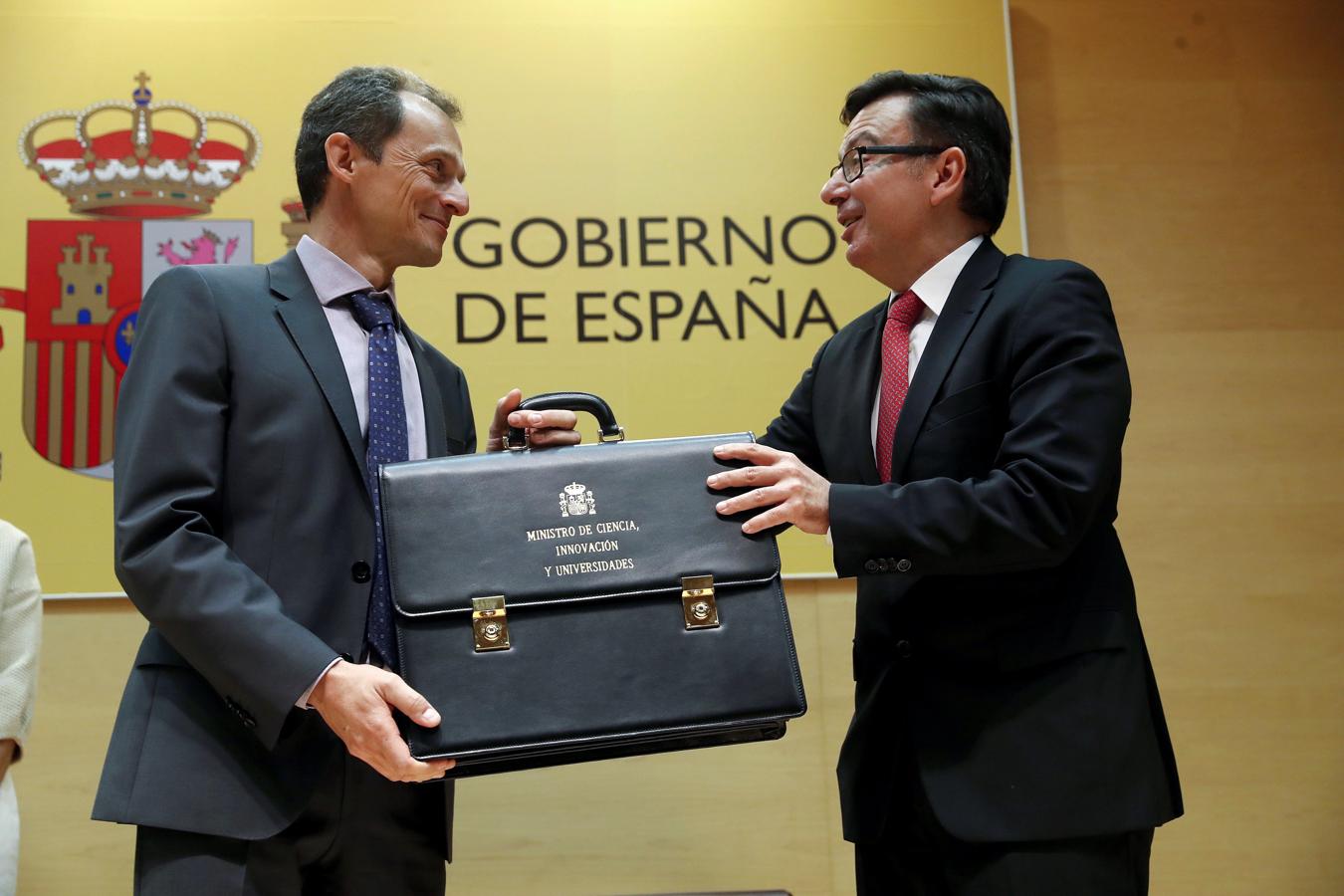 El ministro de Ciencia, Pedro Duque, recibe la cartera de su antecesor en el cargo, Román Escolano (derecha). 