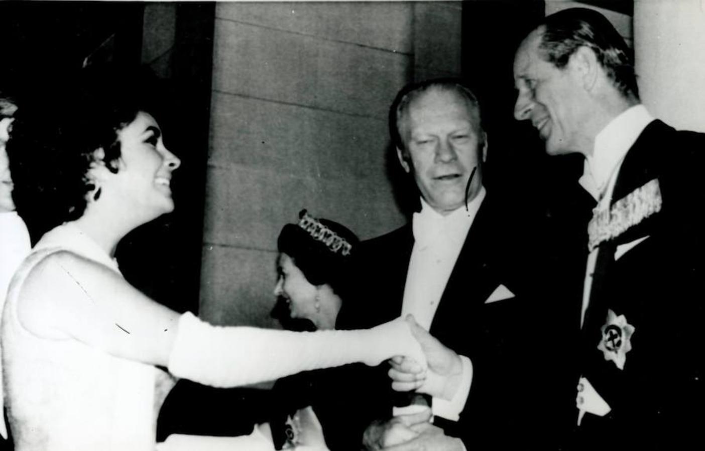 Con una estrella de Hollywod. Felipe de Edimburgo saluda a la actriz Elizabeth Taylor  junto al presidente Ford a su llegada a la embajada de Gran Bretaña en Washington , con el fin de asistir a una cena de gala ofrecida por la Reina Isabel II con motivo de su visita oficial a Estados Unidos.