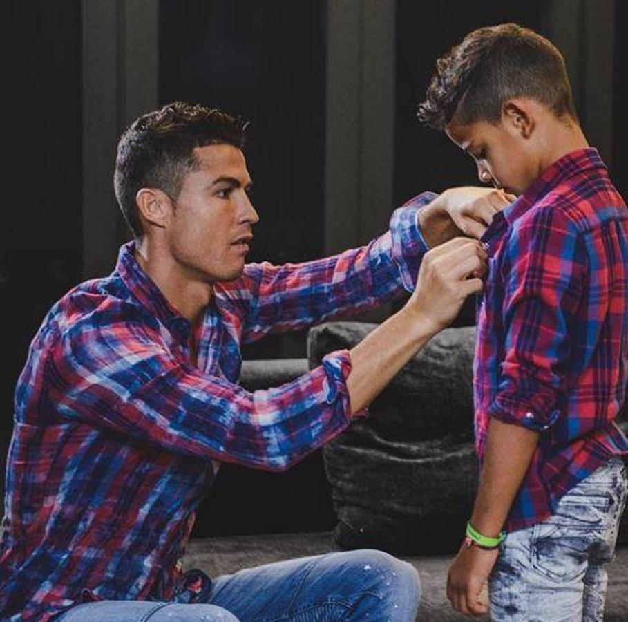 Tal para cual. Cristiano Ronaldo totalmente conjuntado con su hijo mayor demuestra que la complicidad entre ellos es máxima. El futbolista enseña a su hijo y comparte tiernos momentos como este en el que le ayuda a abrocharse los botones de la camisa.