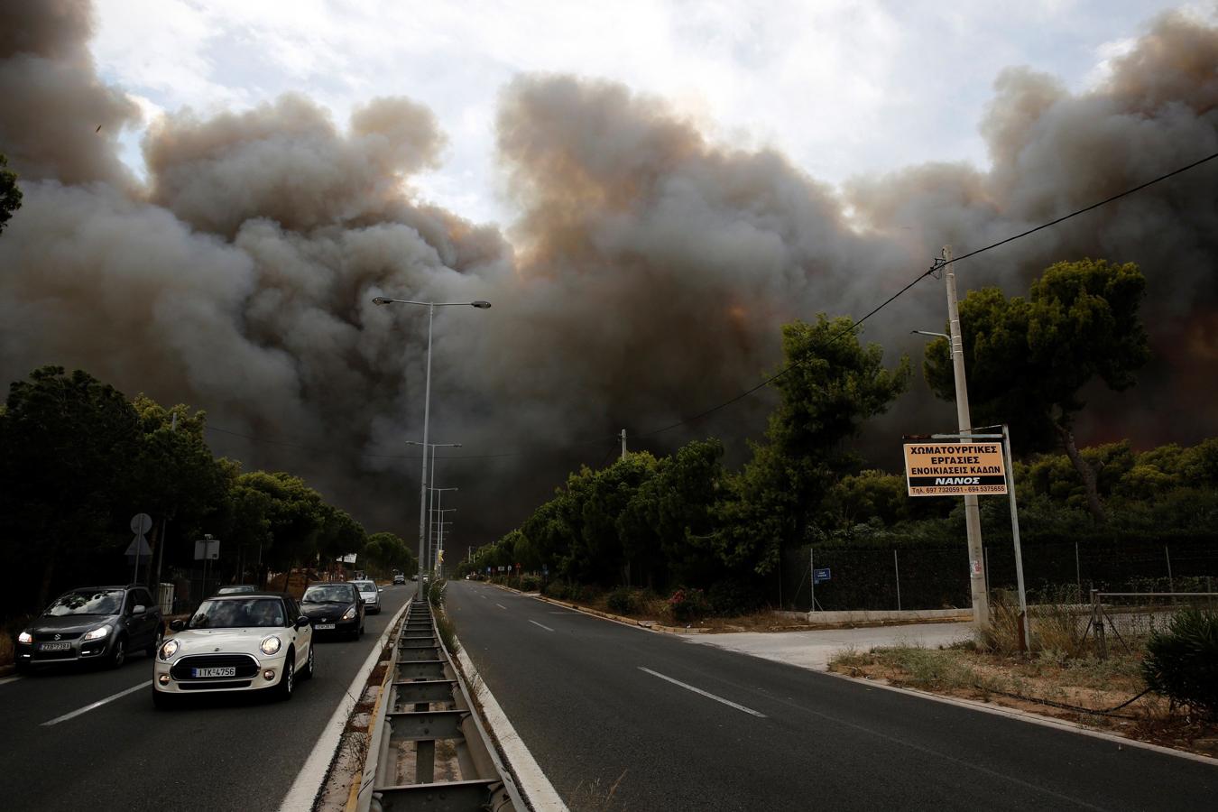 El humo emerge de un incendio, en Neo Voutsa, al norte de Atenas (Grecia). 