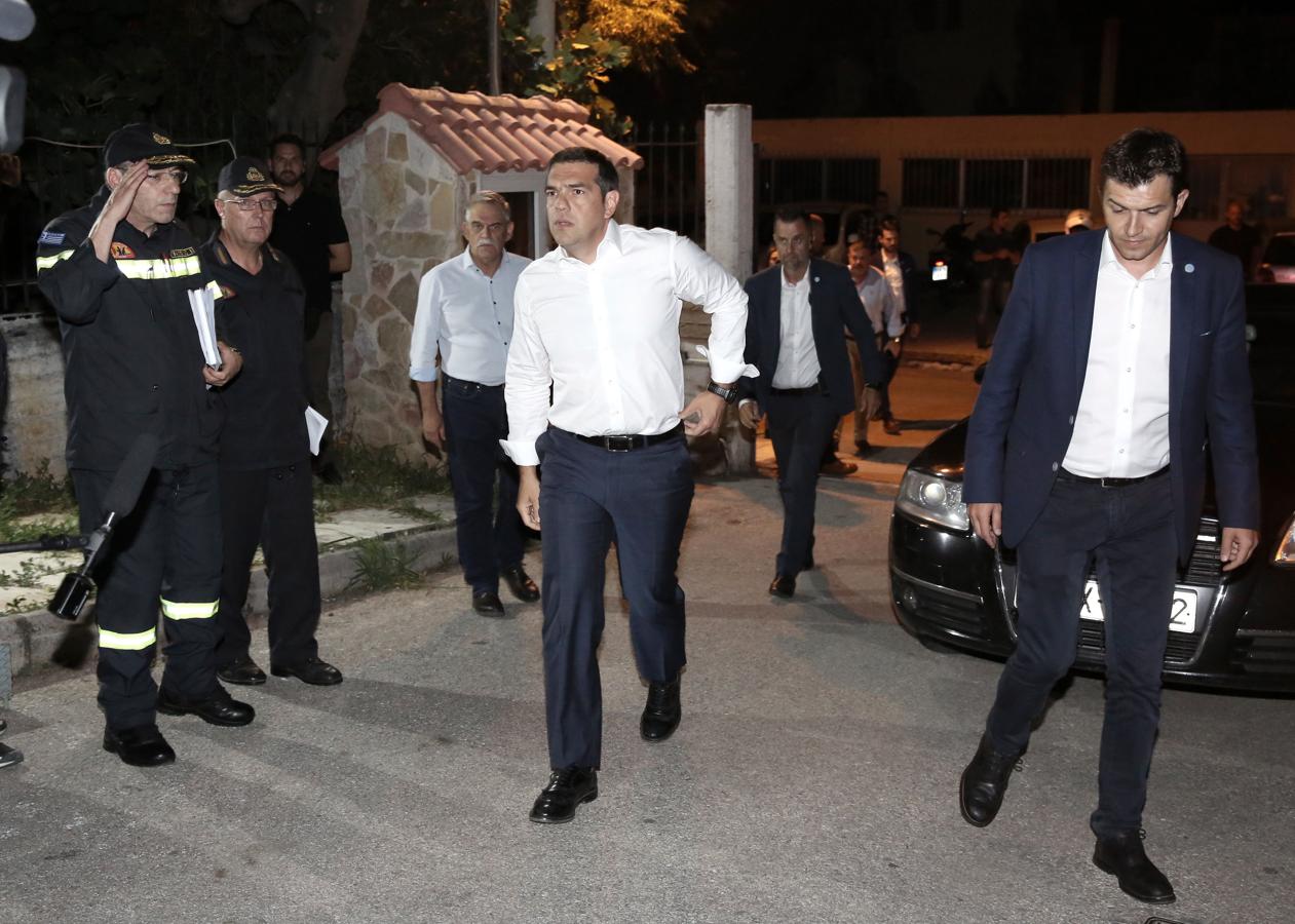 El primer ministro griego Alexis Tsipras (c) asiste al centro operacional de la brigada de bomberos en Atenas (Grecia). 