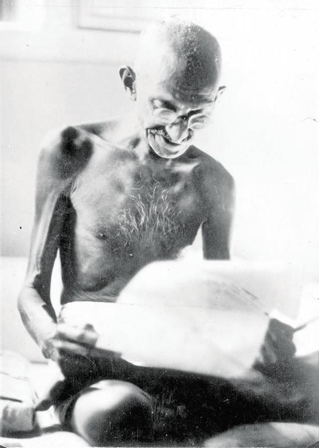 Gandhi leyendo la noticia de su liberación de la cárcel. 