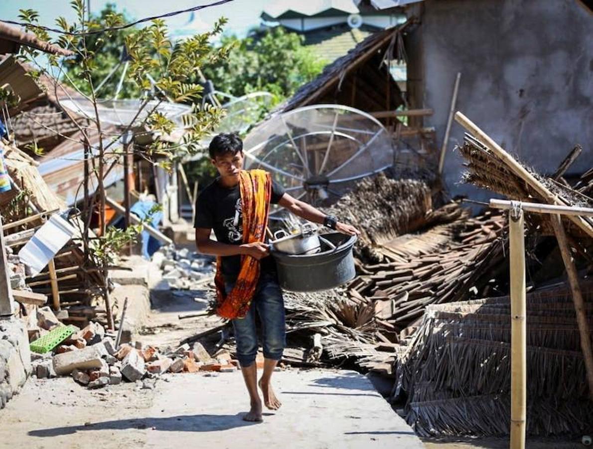 Las devastadoras consecuencias del terremoto. Un hombre camina entre los escombros tras el terremoto de magnitud 6,9 que sacudió la noche del domingo la isla de Lombok, Indonesia.