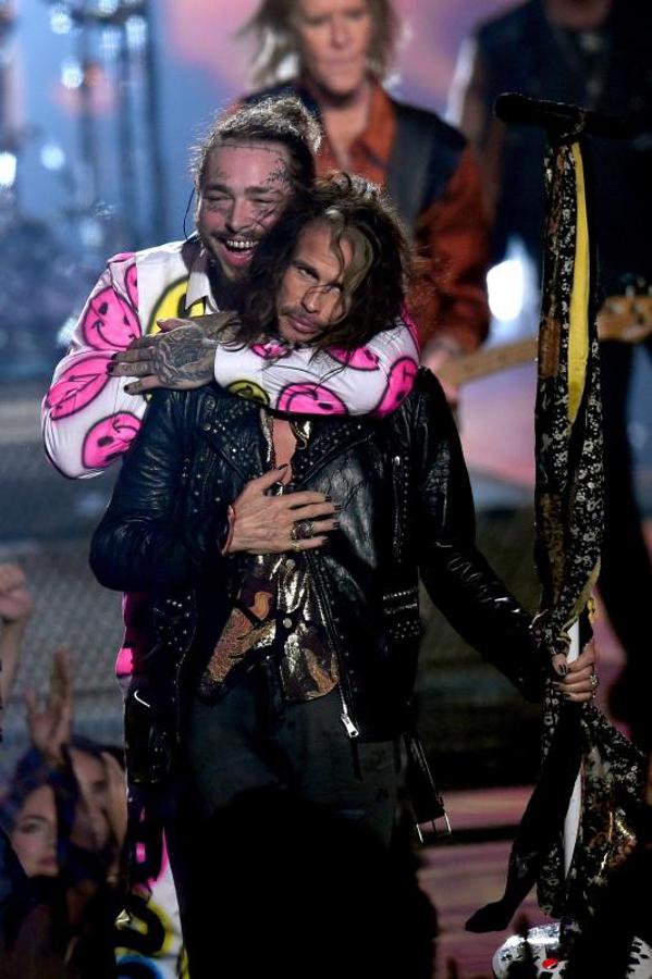 Post Malone abraza al componente del grupo Aerosmith Steve Tyler