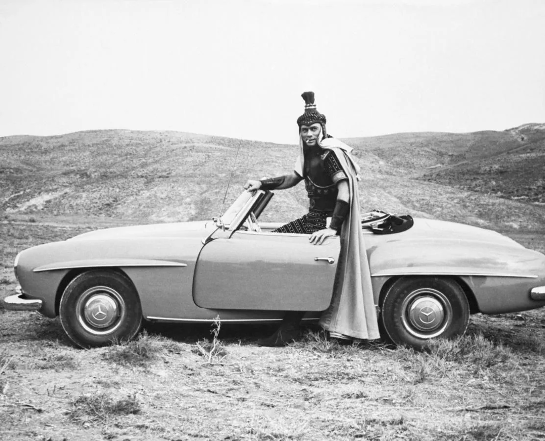 Yul Brinner, caracterizado para su papel en «Salomón y la reina de Saba» setoma un descanso durante el rodaje con su Mercedes-Benz 190 SL, 1959. Getty Images