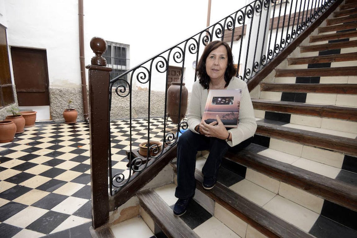 Maribel Pérez, en la escalera de su casa con su álbum de viajes. Fotografía de A. Pérez Herrera