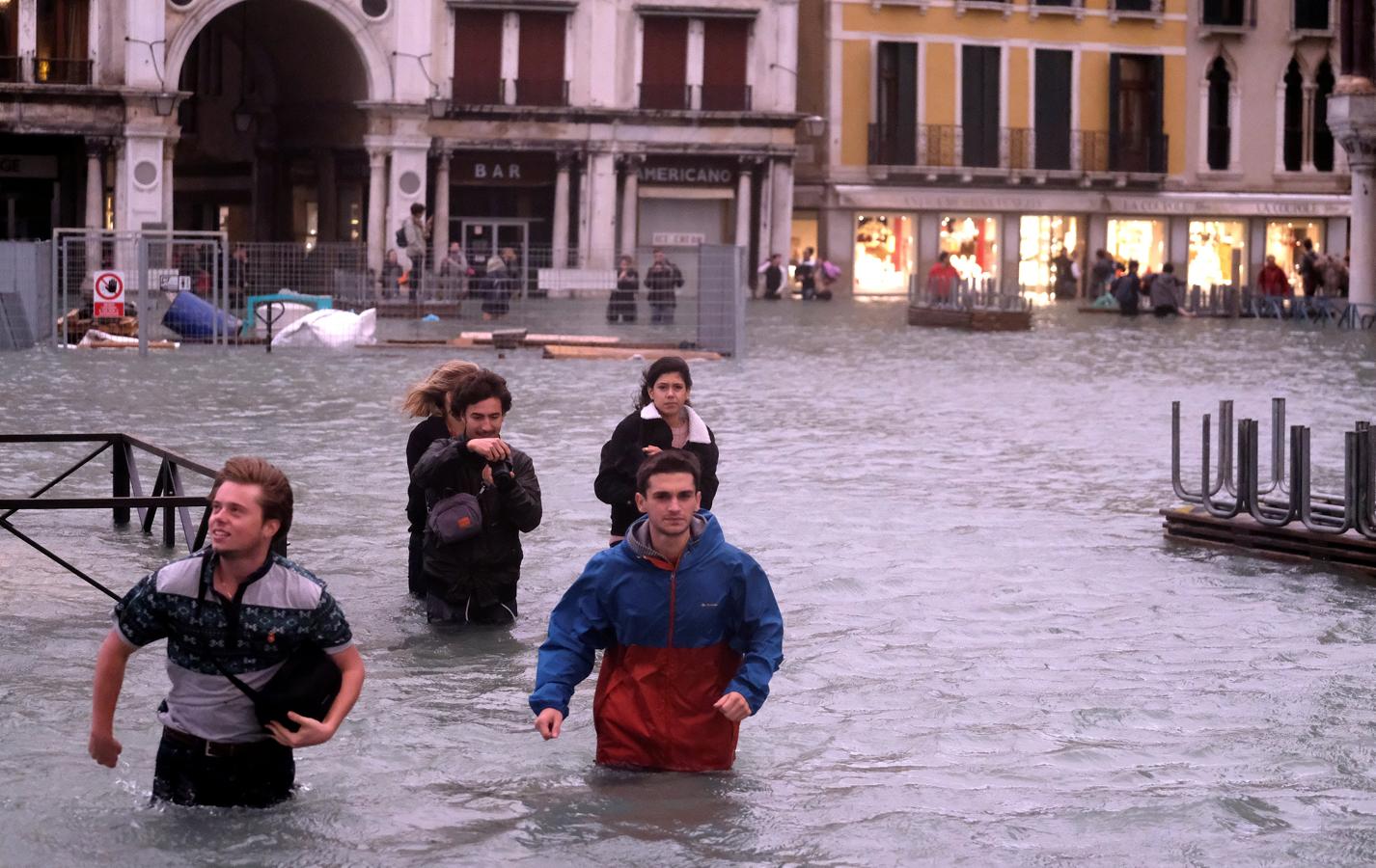 Algunos turistas se lo toman con humor y aprovechan para fotografiar la histórica subida del nivel del agua en Venecia.. 