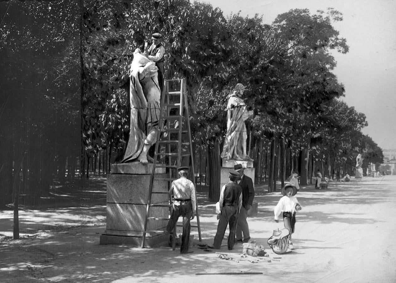 4.. Madrid, septiembre de 1906. Obreros colocando la cabeza de uno de los reyes de piedra del Paseo de las Estatuas del Retiro