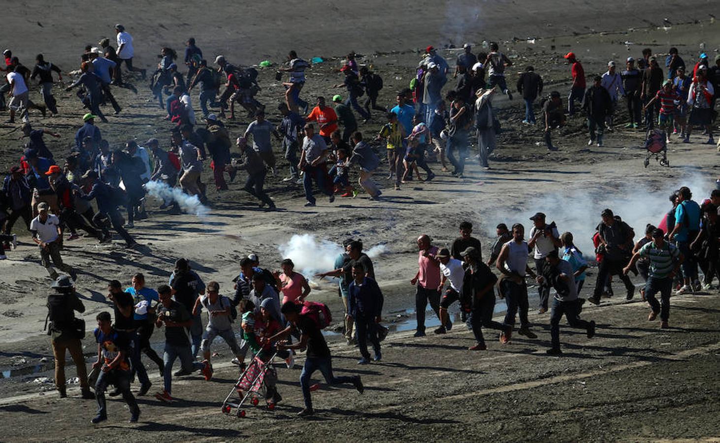 Cientos de inmigrantes tratan de cruzar por la fuerza la frontera entre México y EE.UU. en Tijuana. Los miembros de la caravana rompen el cerco policial y corren para intentar pasar a Estados Unidos