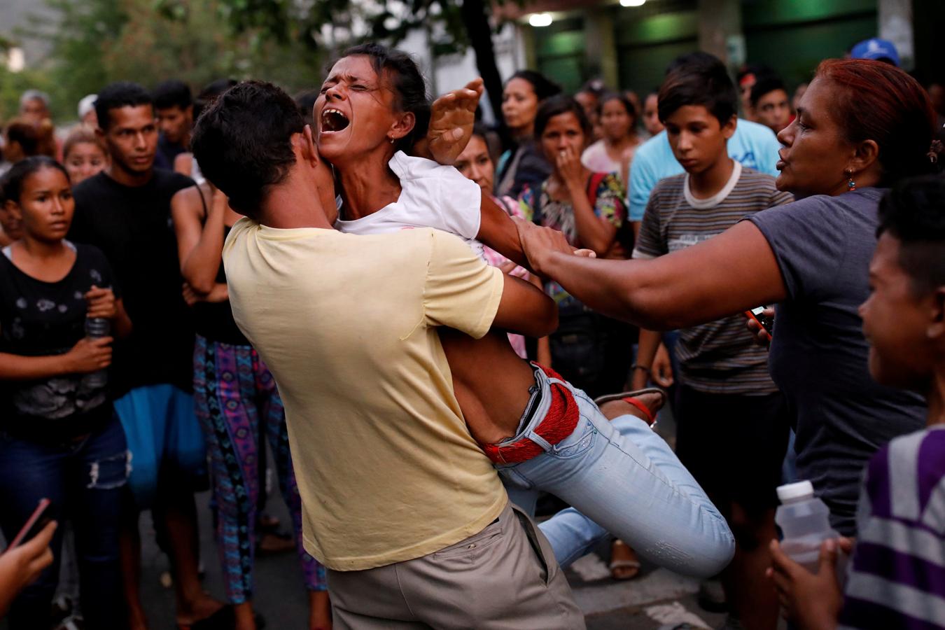 Los familiares de los internos recluidos en el Comando General de la Policía de Carabobo reaccionan mientras esperan fuera de la prisión, donde ocurrió un incendio en el área de las celdas, según medios locales, en Valencia (Venezuela), el 28 de marzo de 2018.. 