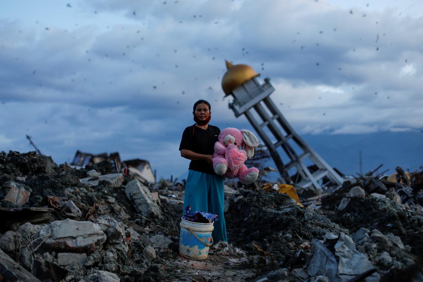 Una mujer sostiene un peluche después de que lo encontraran en su casa destruida donde dijo que había perdido a sus tres hijos, en Palu, Sulawesi Central, Indonesia, el 7 de octubre de 2018.. 