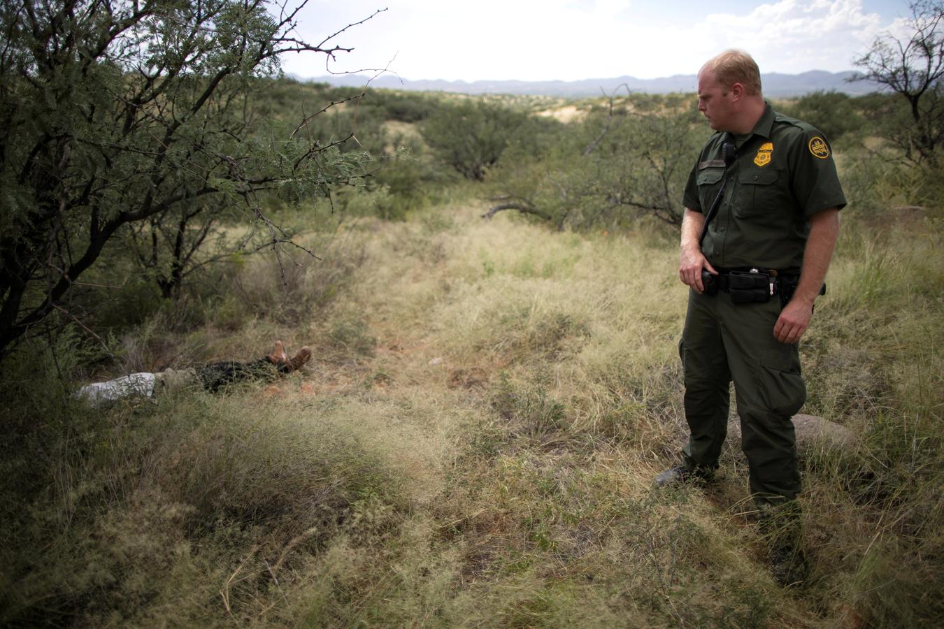 El agente de la Patrulla Fronteriza Jacob Stukenberg observa a la migrante guatemalteca Misael Paiz, de 25 años, quien murió en el desierto de Sonora después de recorrer más de 2.000 millas para cruzar la frontera de Estados Unidos y México, en el Refugio Nacional de Vida Silvestre de Buenos Aires en el condado de Pima, en Arizona (EE.UU.). Foto tomada el 10 de septiembre de 2018.. 