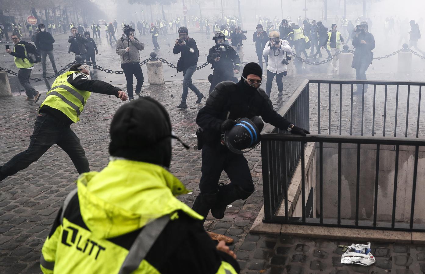 «Chalecos amarillos» se enfrentan a los antidisturbios en los Campos Elíseos de París. 