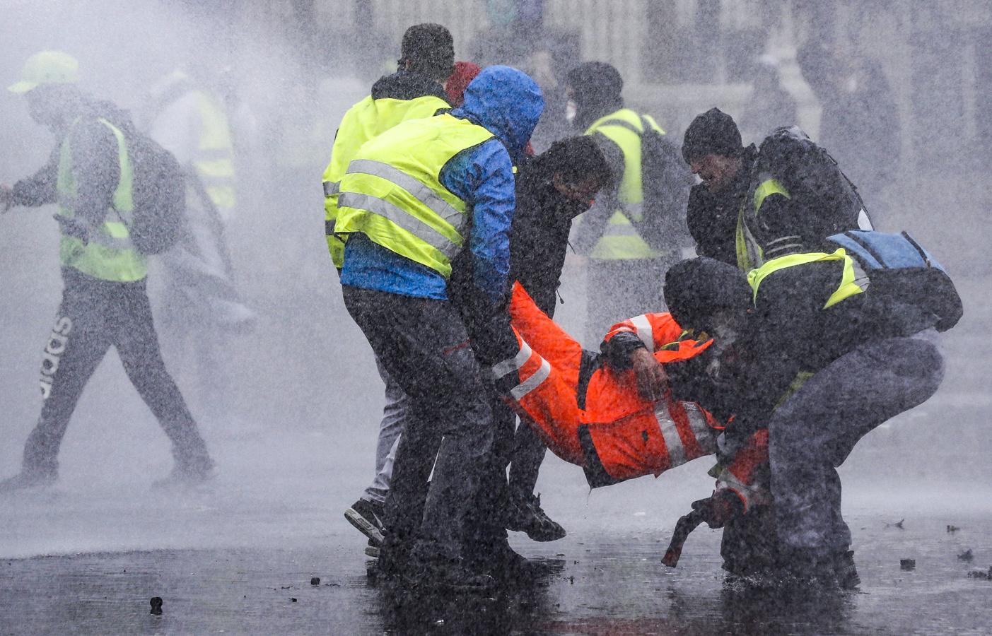 «Chalecos amarillos» retiran a un manifestante herido durante las protestas.. 