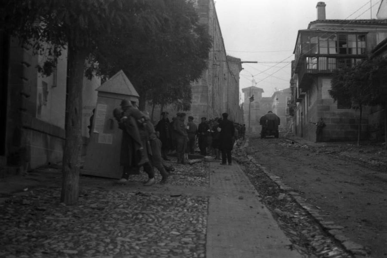 La infantería avanzaba parapetada hacia la catedral, mientras el blindado ascendía la calle. Un herido era retirado a hombros. 