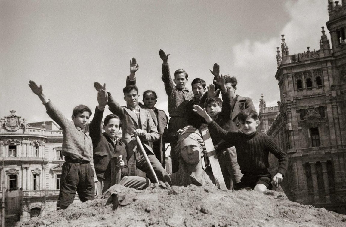 Niños, en alto durante las obras de desescombro de la Cibeles en 1939, que estuvo protegida durante la Guerra Civil, nada más terminar la contienda. 