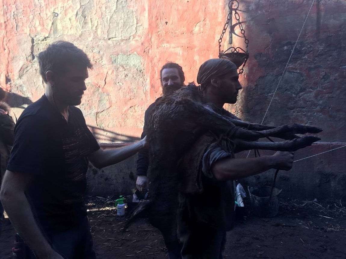 Un figurante acarreando un corzo muerto. 