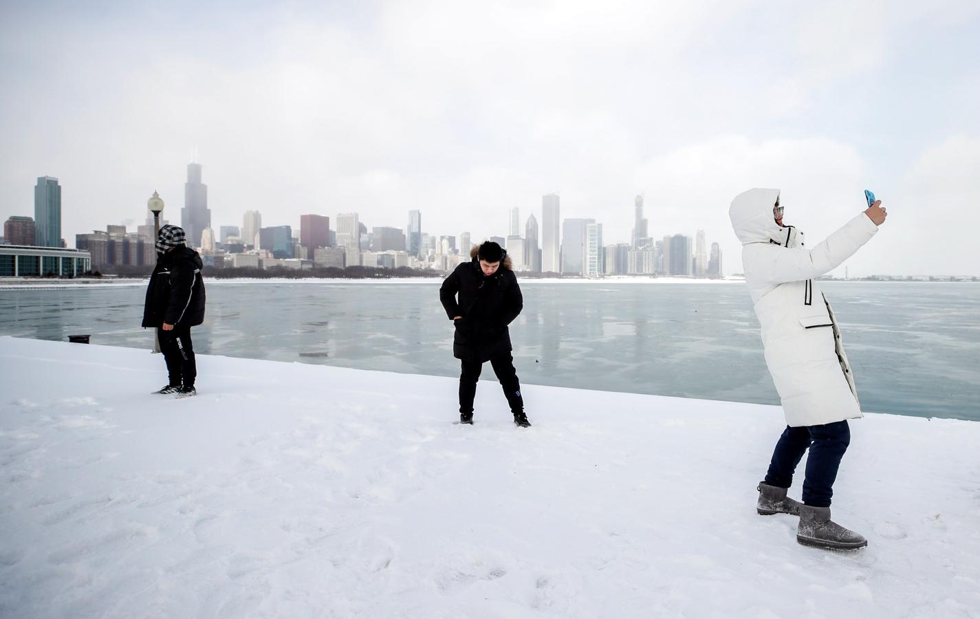 Un hombre se fotografía junto a las aguas heladas del lago Michigan en Chicago.. 