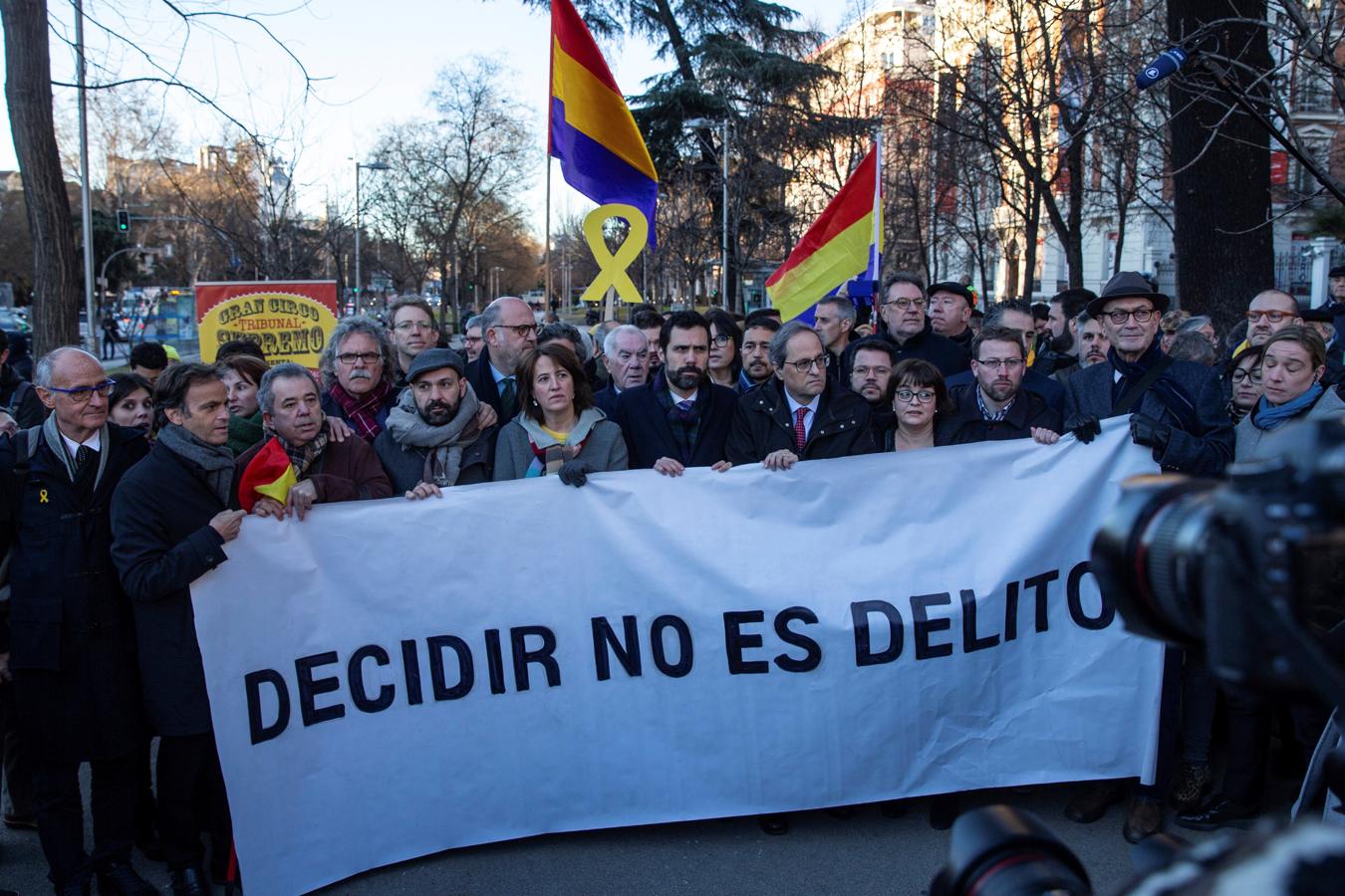 El presidente de la Generalitat, Quim Torra (4d), y el presidente del Parlament, Roger Torrent (5i), tras una pancarta con el lema «Decidir no es delito», a su llegada al Tribunal Supremo.. 