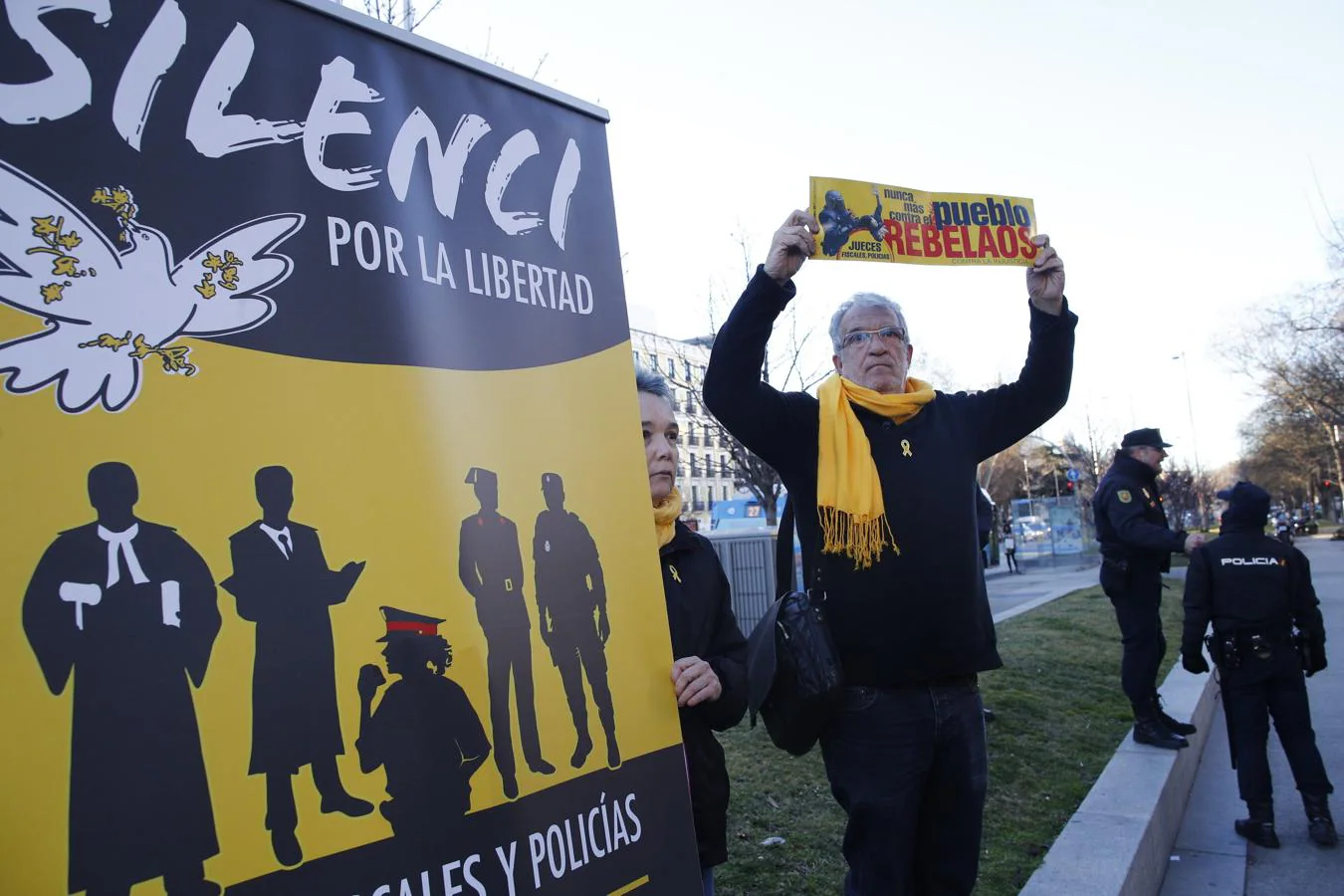Una persona con lazo y bufanda amarilla y con un cartel que induce a la justicia a colaborar con el independentismo en una concentración frente al Tribunal Supremo, donde se celebra el juicio del «procés» contra políticos independentistas catalanes.. 