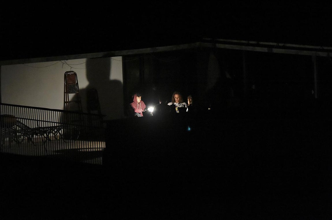 Un grupo de personas disfruta de la luz de una linterna en Caracas, en una nueva jornada de apagón. 