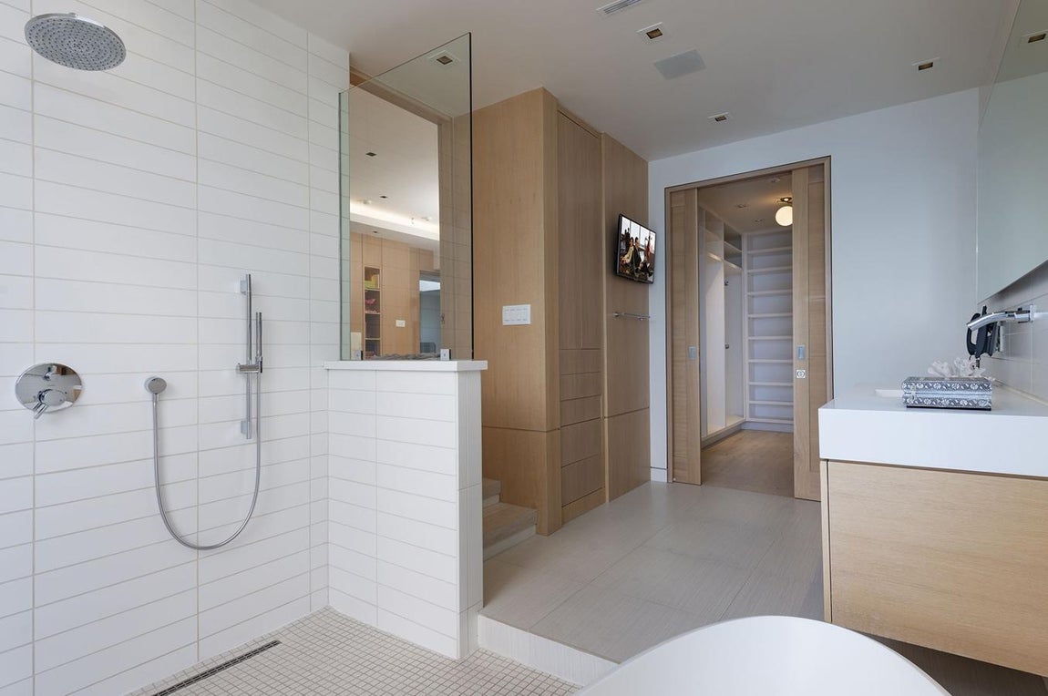 Piezas funcionales. El diseño, limpio y eminentemente práctico de las piezas de baño conjuga con su distribución espacial. Ducha y bañera a un lado, al otro, un gran armario y un vestidor