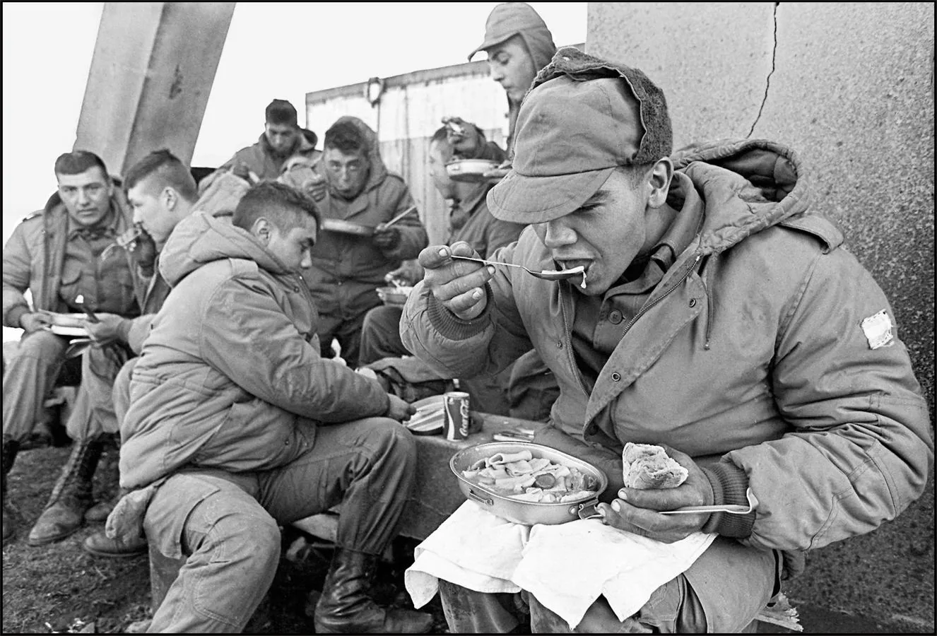 La imagen muestra a los soldados argentinos almorzando en la antigua base de los Royal Marines parcialmente destruida, el 13 de abril de 1982, en Stanley.. 