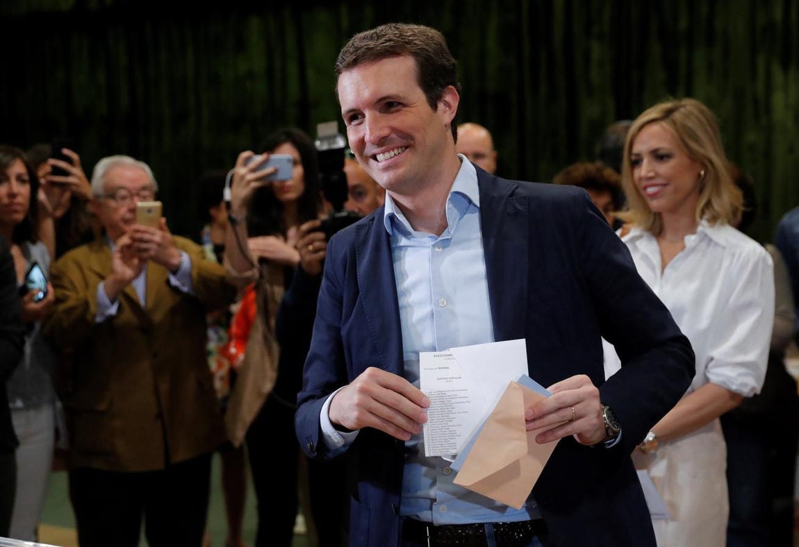 El presidente del PP, Pablo Casado, junto a su esposa, Isabel Torres, vota este domingo en el Colegio Nuestra Señora del Pilar de Madrid.. 