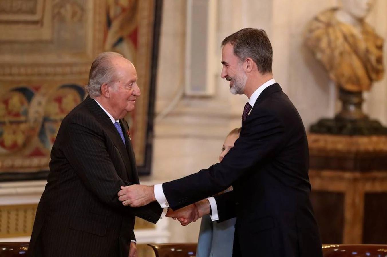30/01/2018.- El Rey emérito Juan Carlos saluda al Rey Felipe VI tras imponerle hoy a la Princesa Leonor el Collar del Toisón de Oro, la máxima distinción que concede la Familia Real española. 
