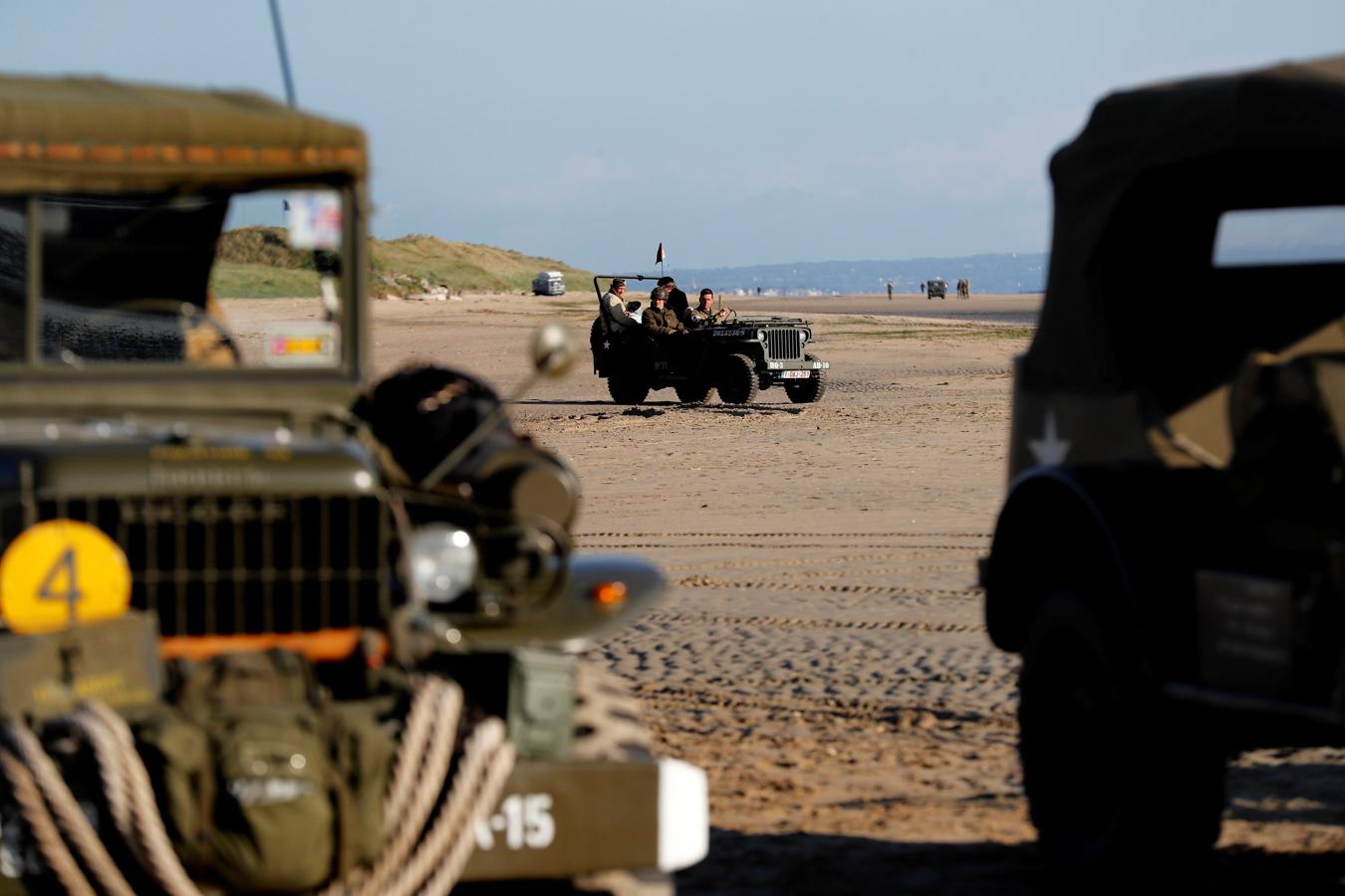 Amantes de la Historia vestidos como soldados de los EE.UU. dirigen un vehículo por la playa Utah antes del comienzo de las celebraciones. 