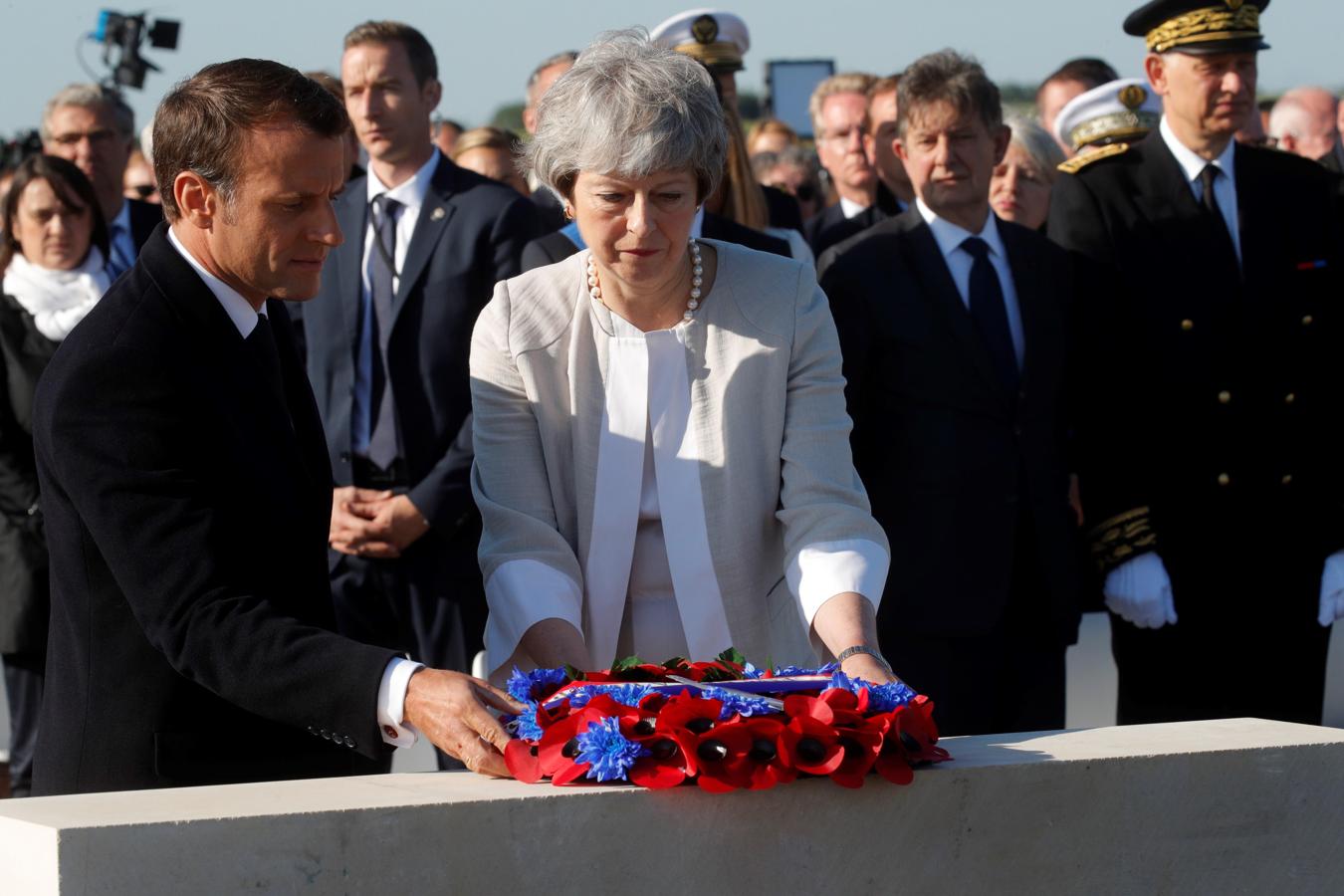 Macron y May realizan una ofrenda floral para honorar a los soldados que realizaron el Desembarco. 