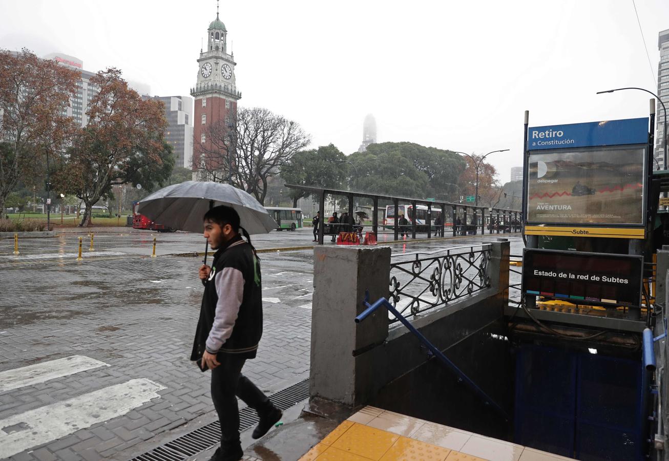 Un hombre camina al lado de una estación de metro cerrada en el centro de Buenos Aires. 