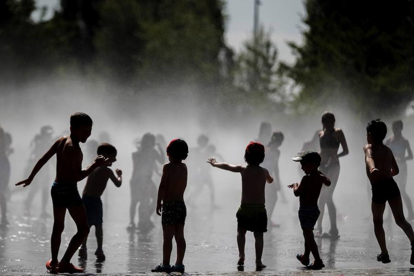 Un grupo de niños se bañan en las fuentes verticales de Madrid Río. La probabilidad apunta a que algunas zonas de la capital se alcance el aviso rojo (riesgo extremo) por altas temperaturas este fin de semana. 