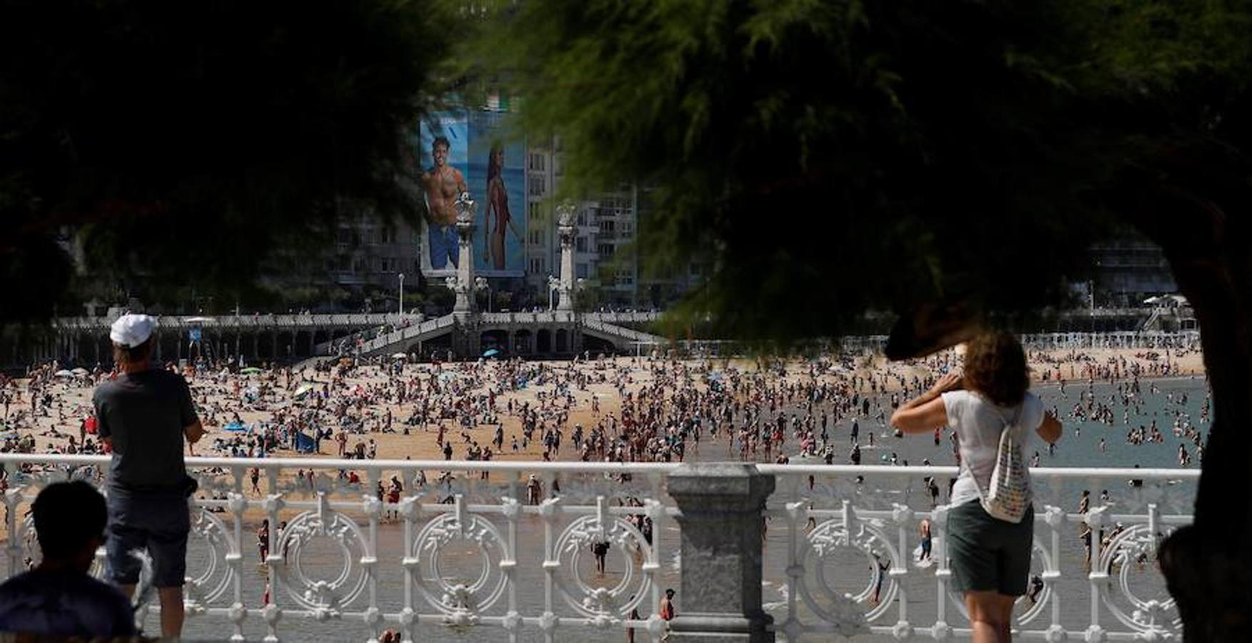 Donostiarras y visitantes combaten el calor este miércoles en la playa de La Concha de San Sebastián. Las altas temperaturas extremas continuarán en Álava este viernes. 