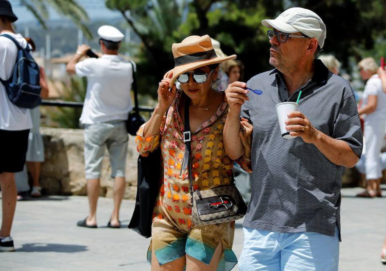 Dos turistas pasean por las calles de Palma de Mallorca bajo el intenso calor. La ola de calor ha activado la alerta amarilla en el sur, el interior y la Tramuntana de Mallorca. 