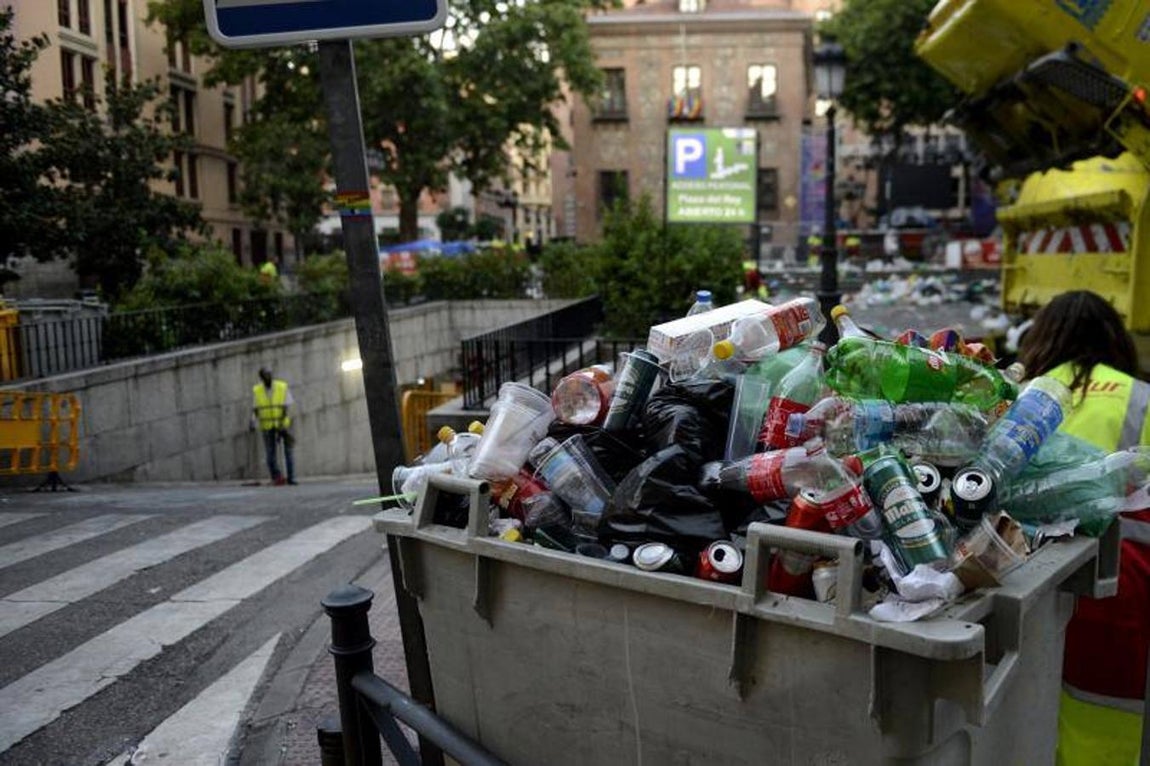 2. Un operario del parking muncipal de la Plaza del Rey repasa la rampa de acceso, a primera hora de la mañana. En primer plano, uno de los muchos contenedores llenos que los servicios municipales de limpieza han tenido que retirar a lo largo de este domingo