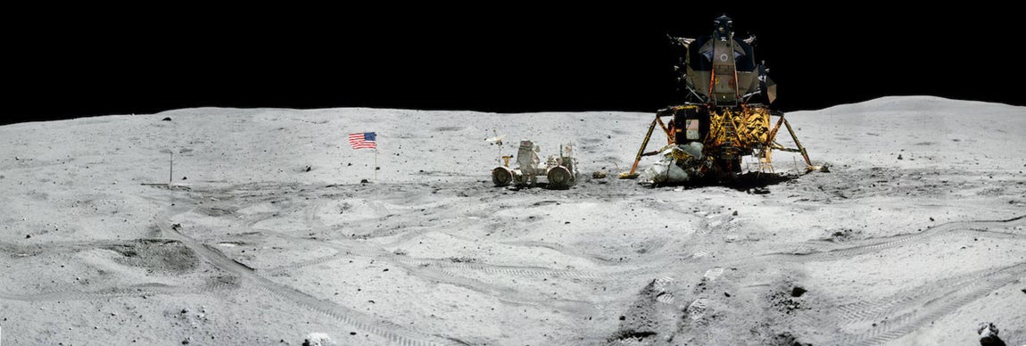 El Apollo 16 junto a una bandera de Estados Unidos. 