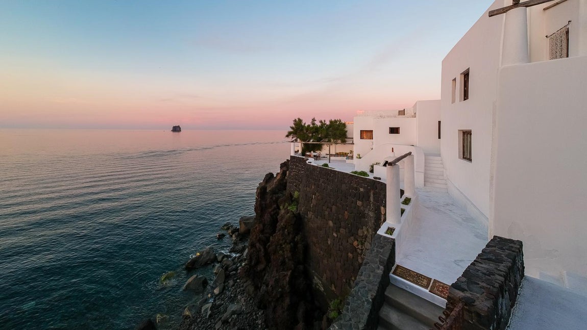 Situada en la pendiente del volcán Stromboli, al norte de Sicilia. Según la agencia inmobiliaria que se está encargando de la venta, Lionard Luxury Real Estate, esta propiedad «se asoma sobre un pedazo de roca a pico sobre el mar y nace de la perfecta fusión de tres típicas construcciones locales de perfiles sinuosos y de color blanco cándido, armoniosamente colocadas en este lugar de encuentro entre el hombre y el paisaje».