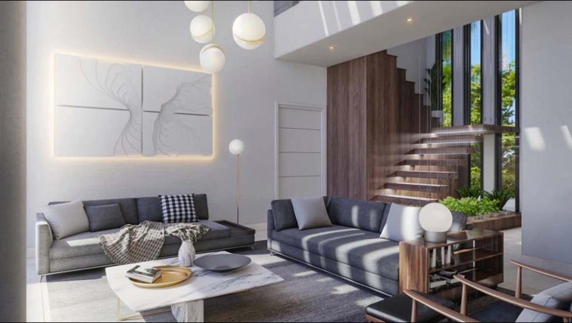 Salón. Ya en el exterior encontramos un comedor para esta temporada en la que apetece disfrutar de las altas temperaturas, con sillas transparentes y mesa de mármol blanca. Alrededor, hamacas, más butacas y un pequeño terreno de césped.