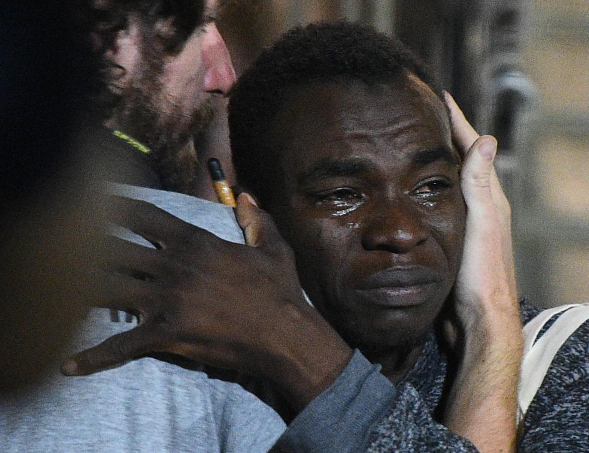 Un inmigrante aparentemente emocionado es consolado por uno de los voluntarios de la nave española. 