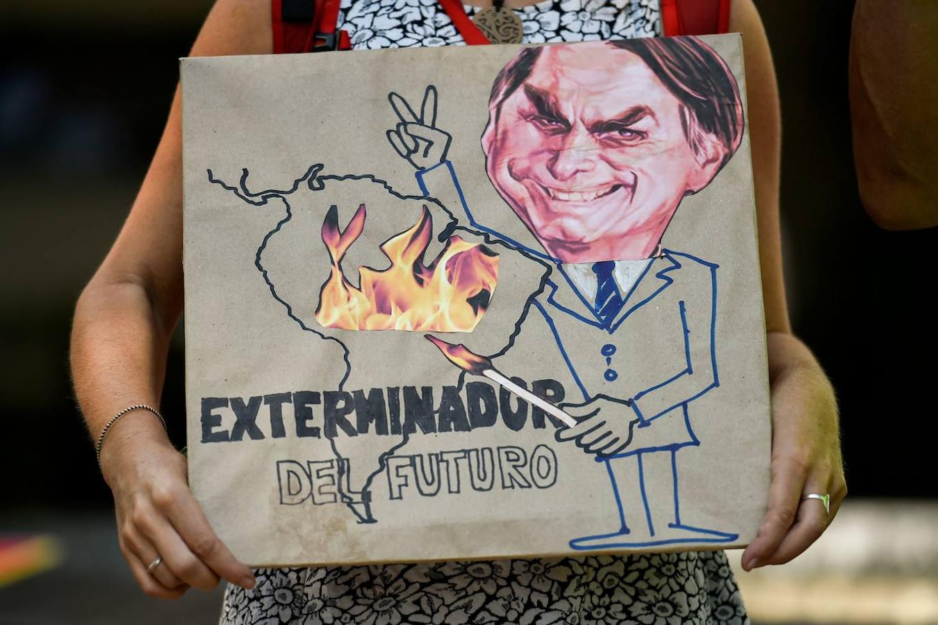 Una activista del cambio climático sostiene un cartel que representa a Jair Bolsonaro con el lema «Exterminador del futuro», durante una protesta contra el líder brasileño por los incendios en la selva. 