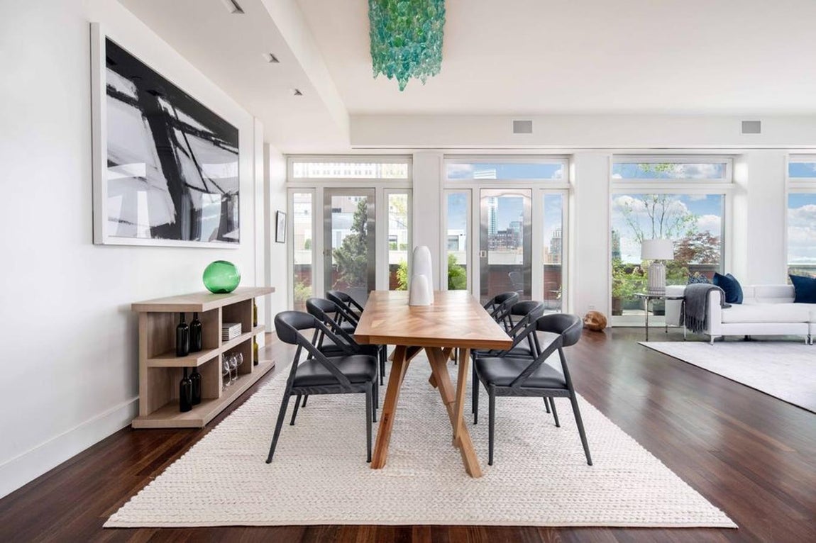 Comedor. Junto al enorme salón, que tiene una cristalera que da al jardín, se encuentra un comedor contiguo y una pequeña sala de estar que se separa de un pequeño muro.