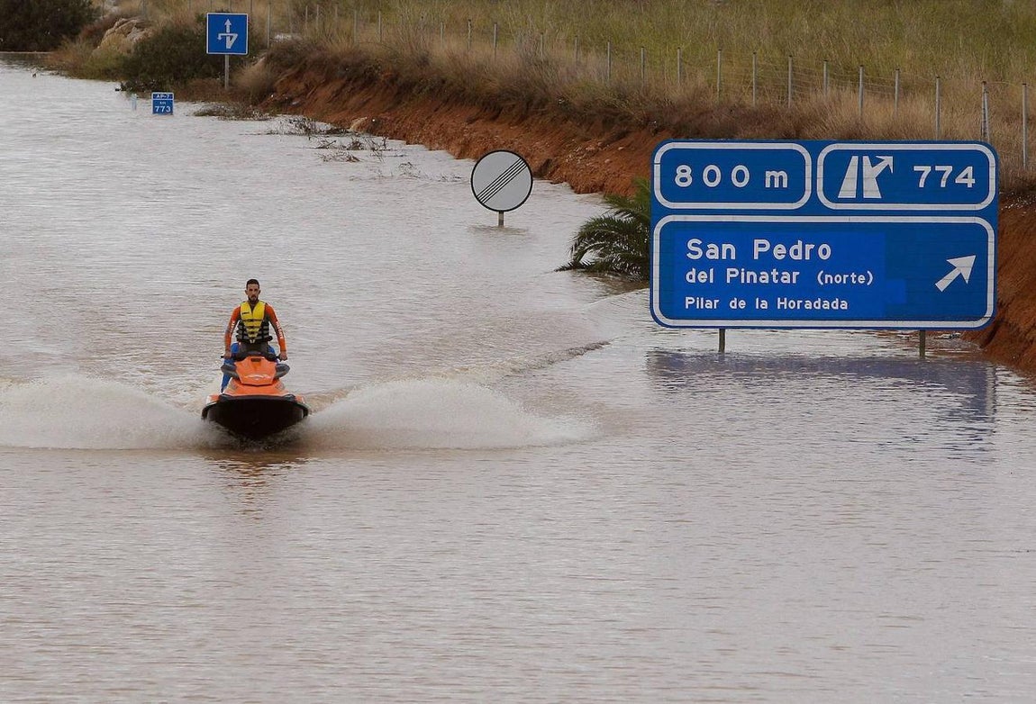 Un miembro de los servicios de rescate cruza en moto acuática la salida del túnel de la AP-7 a la altura del municipio alicantino Pilar de la Horadada. 