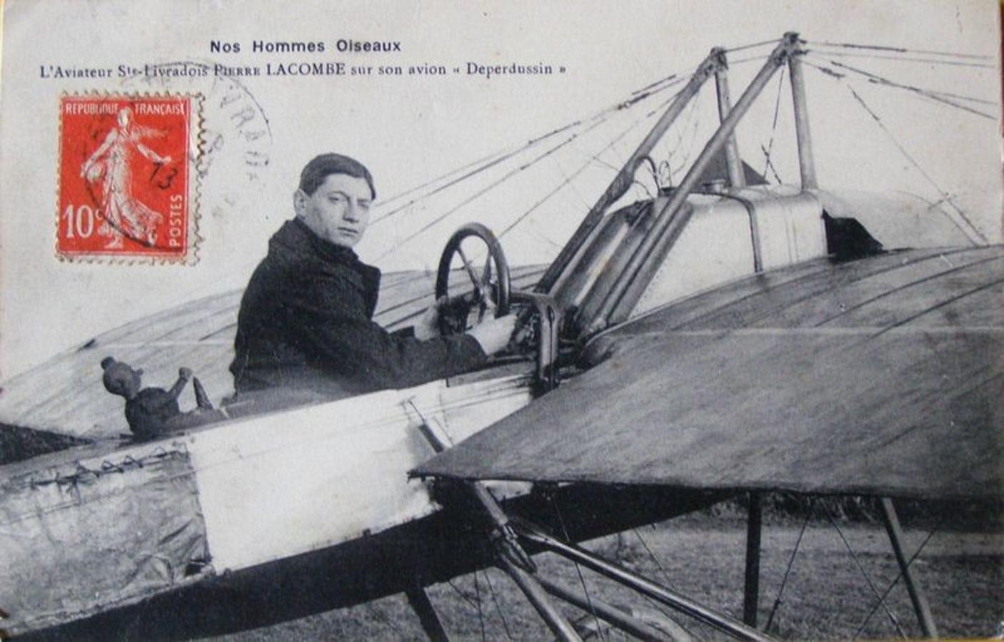 Pierre Lacombe en una postal francesa. Tras él, un muñeco de trapo, su amuleto que también incluyó en su vuelo en Toledo, el 5 de junio de 1912. 