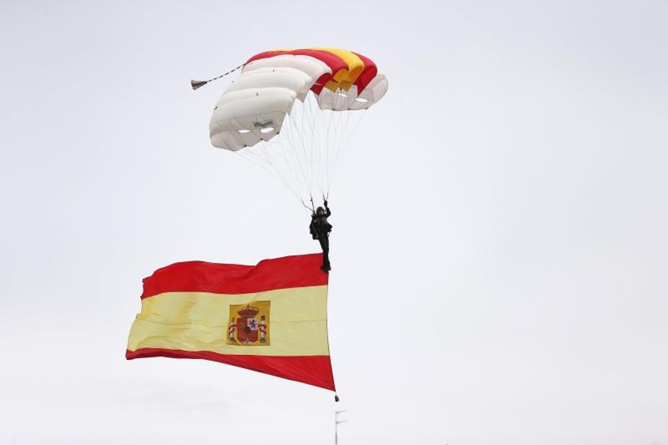 El miembro de la Brigada Paracaidista que descendía portando la bandera de España, momentos antes de tomar tierra en el madrileño Paseo de la Castellana. 