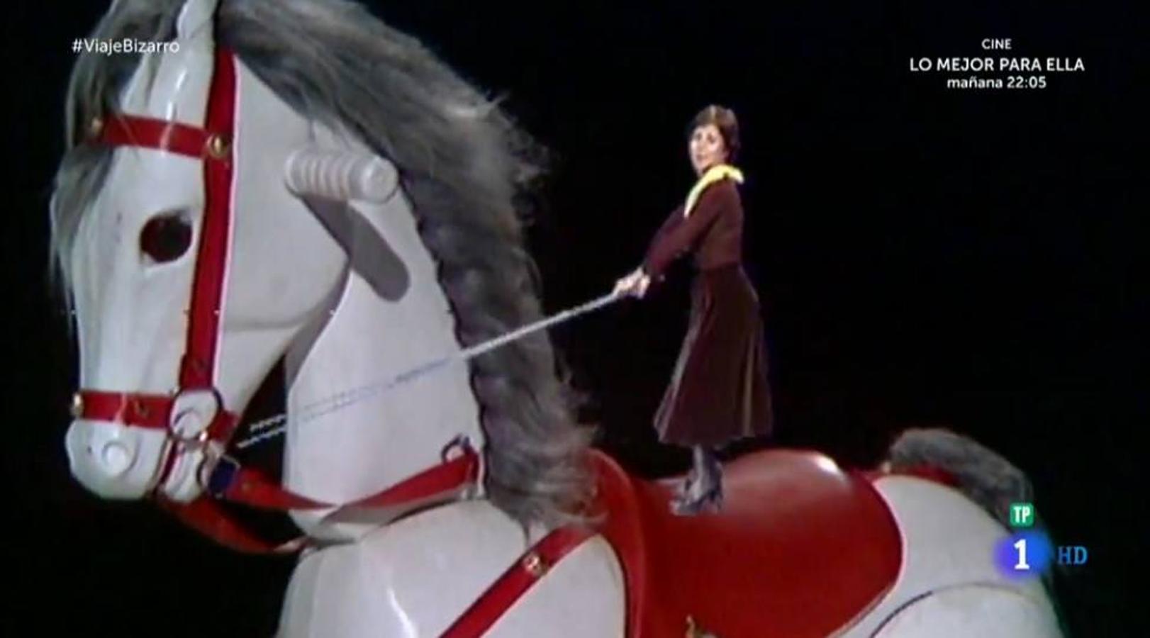 Lina Morgan sobre los lomos de un caballo de madera gigante. 