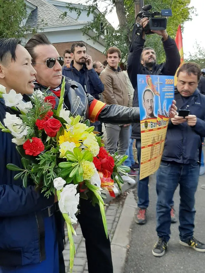 Un manifestante de origen oriental porta flores en una pequeña concentración de franquistas en las inmediaciones del cementerio de El Pardo Mingorrubio antes de la inhumación de los restos de Francisco Franco en El Pardo.. 