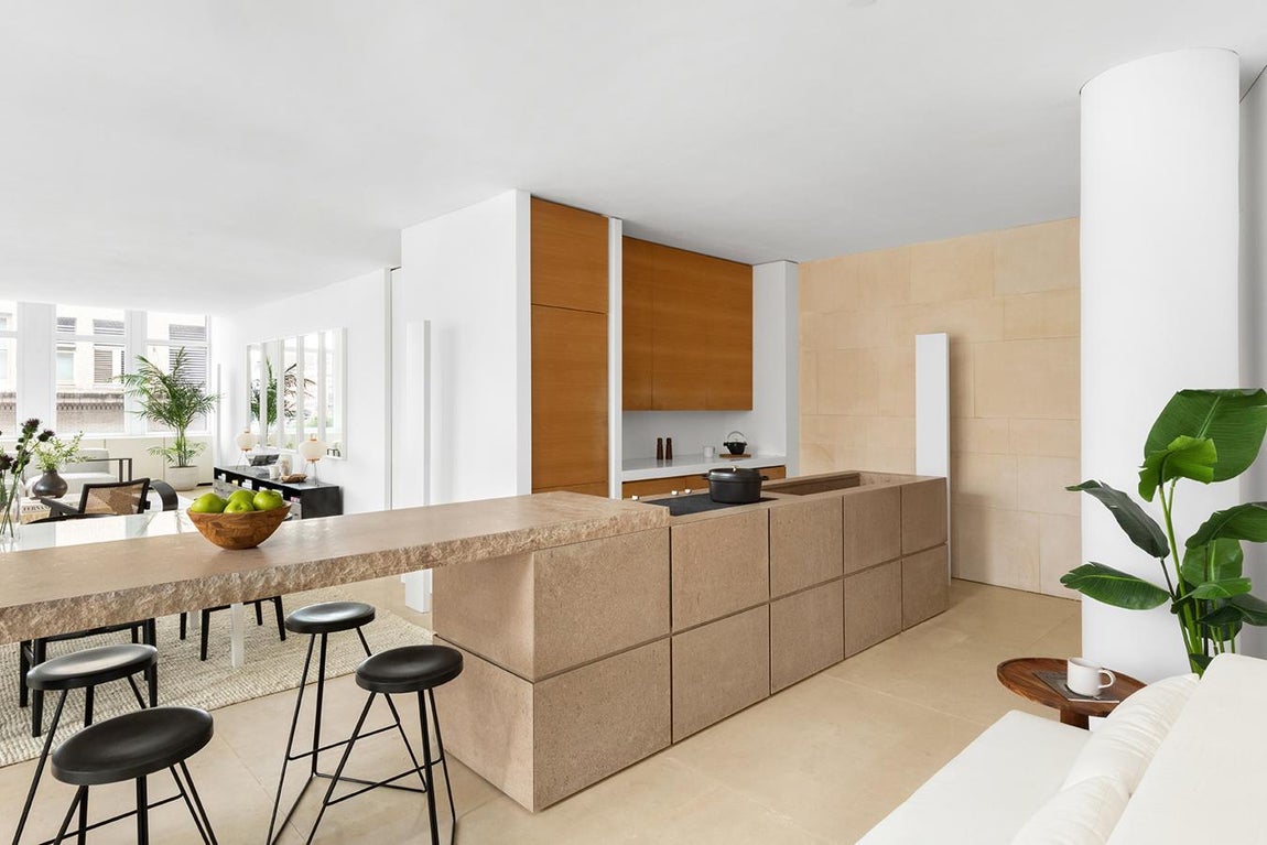 El loft minimalista de Kim Kardashian. Su cocina, con una isla de piedra para desayunar o comer, cuenta con muebles de peral y pavimiento de piedra caliza francesa y electrodomésticos de Subzero y Miele.